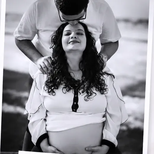 Ensaio fotográfico de gestante em preto e branco, com o casal abraçado ao ar livre