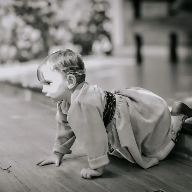 Ensaio fotográfico infantil em preto e branco, com bebê engatinhando